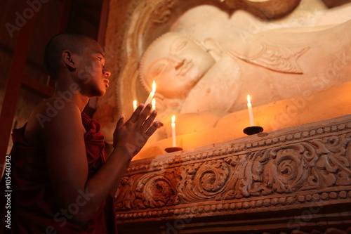 Buddhistischer Mönch beim Gebet im Kerzenschein  photo