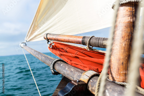 Photos wooden bowsprit, mast, jib sail blew up by the wind and yardarm with an ocher sa
