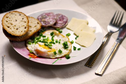 light breakfast on the table with egg, bread, cheese and sausage