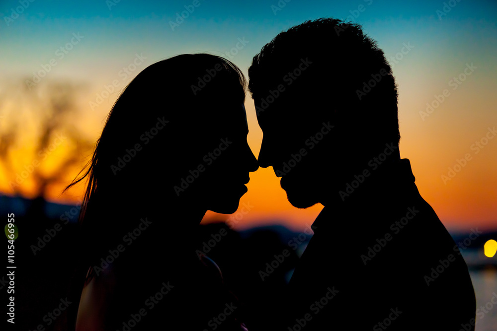 Silhouette of a couple kissing on sunset