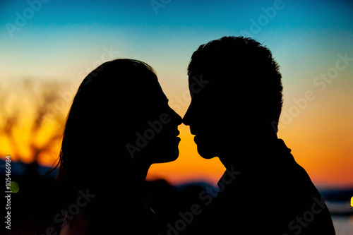 Silhouette of a couple kissing on sunset