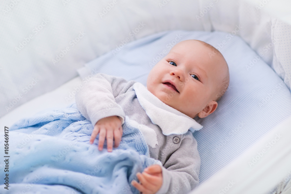 Baby boy in a crib under knitted blanket Baby boy in a crib under knitted blanket