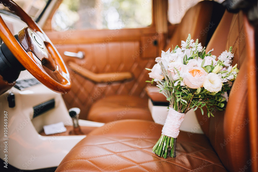 Wedding bouquet of the bride in the car