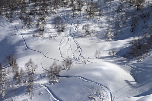 Off-piste slope with track from ski and snowboard on sunny day © BSANI