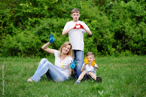 Mother and sons playing on the background of green trees. Mom an