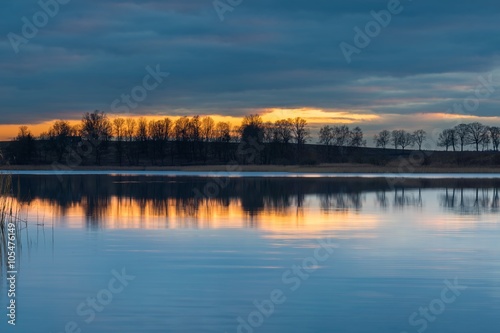 Close up of opposite shore of lake after sunset