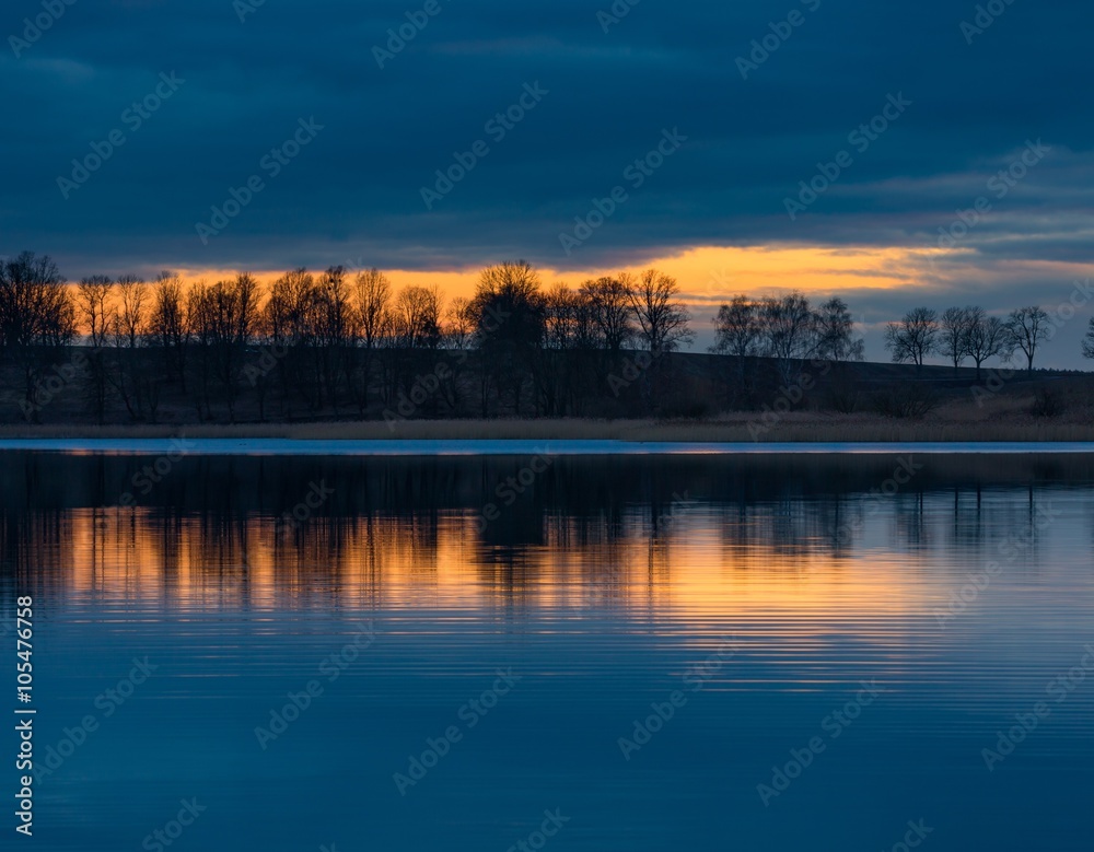 Close up of opposite shore of lake after sunset