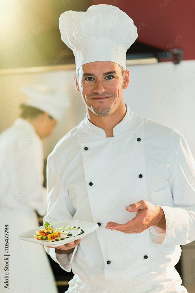 Portrait of a man chef presenting a plate of fine food. Portrait of a man chef presenting a plate of fine food.