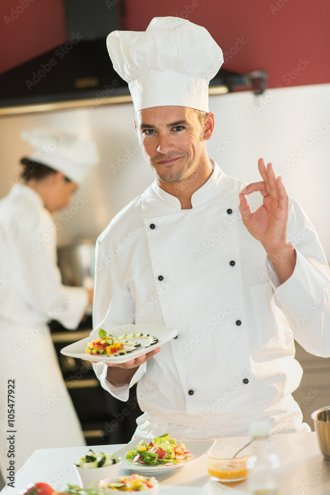 Portrait of a man chef presenting a plate of fine food.