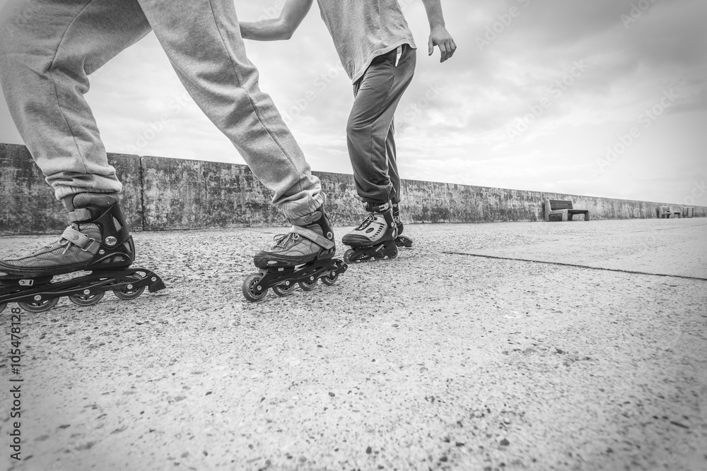 Two people race together riding rollerblades. Two people race together riding rollerblades.