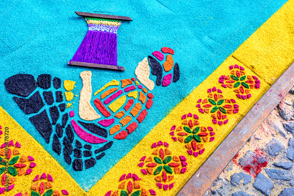 Fototapeta premium Detail of indigenous woman weaving on handmade dyed sawdust Lent carpet for procession, Antigua, Guatemala
