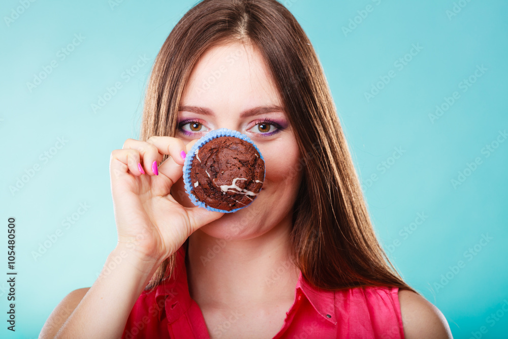 Funny woman holds cake in hand covering her face Funny woman holds cake in hand covering her face