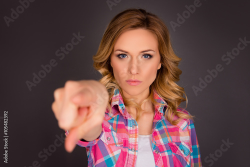 Valokuva Challenge! Strict young woman pointing on camera on gray backgro