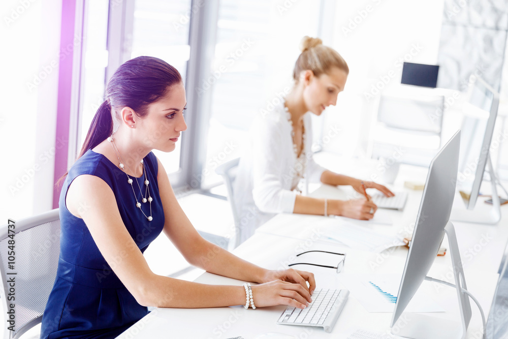 Attractive office worker sitting at desk Attractive office worker sitting at desk