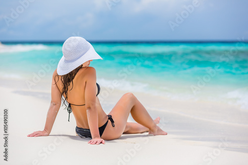 Young woman in bikini sitting on the beach