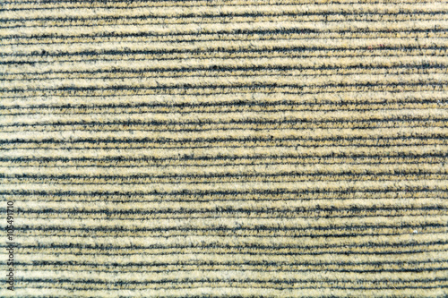 Background texture of beige and black striped velvet closeup
