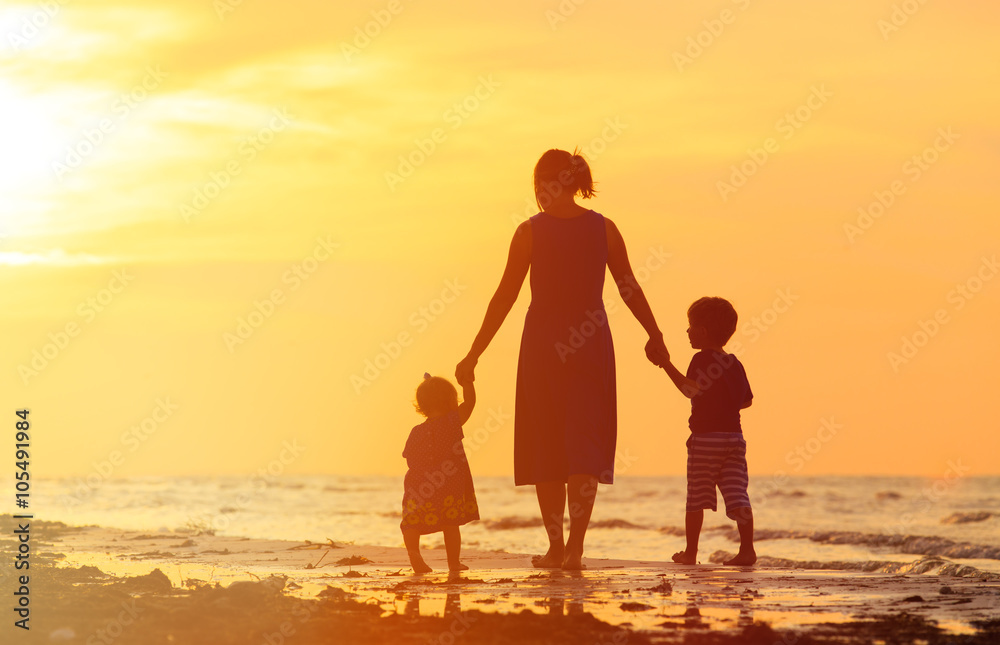 mother and two kids walking on beach at sunset mother and two kids walking on beach at sunset