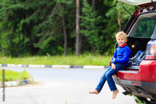 happy little boy travel by car in summer