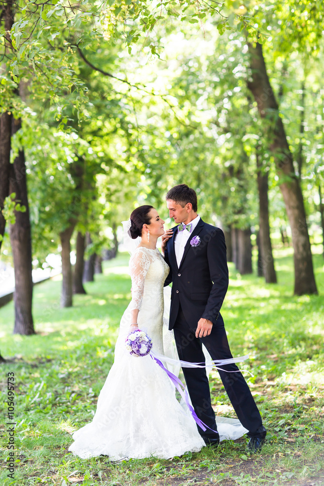 Elegant bride and groom posing together outdoors on a wedding day Elegant bride and groom posing together outdoors on a wedding day