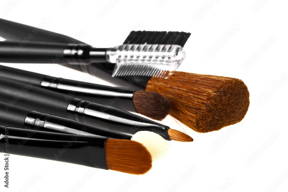 Fototapeta premium Bunch of make-up brushes lying randomly on white background