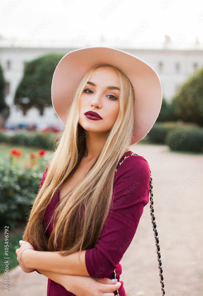 ondeugd nicht Aas Outdoor fashion portrait of young seductive woman,wear casual outfit,posing  with bag and hat,big pink hat blonde with red lips posing on the  street,full red lips,big blue eyes,long hairs,keratin hair Stock Photo 