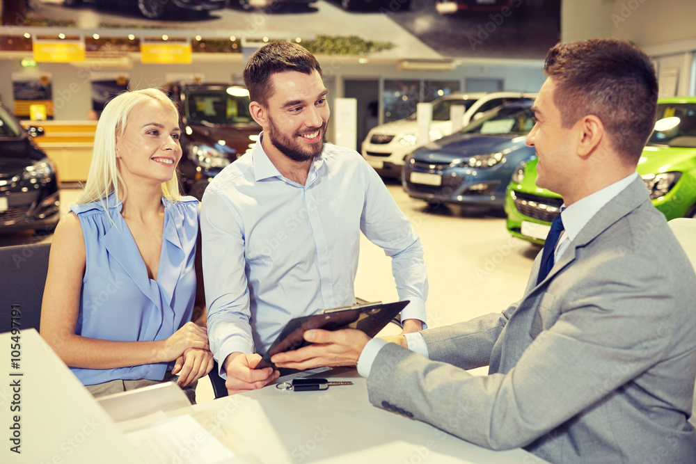 happy couple with car dealer in auto show or salon happy couple with car dealer in auto show or salon