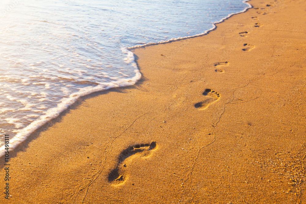 beach, wave and footprints at sunset time beach, wave and footprints at sunset time