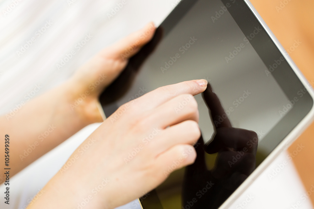 close up of woman hand with tablet pc at home