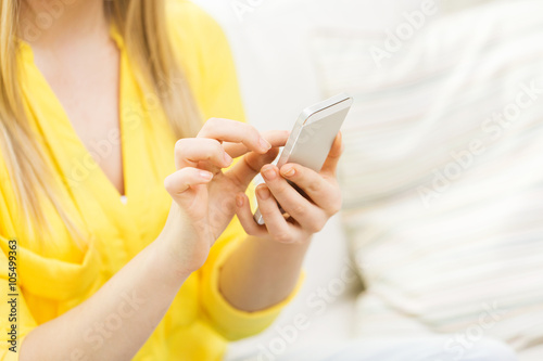 close up of woman texting on smartphone at home
