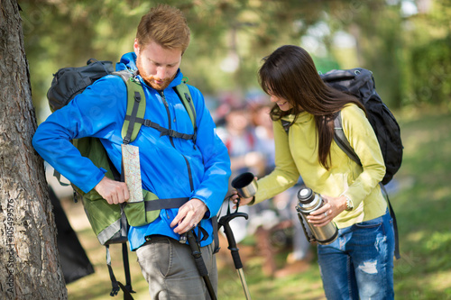 Guy put map in pocket and girl gives him fresh water