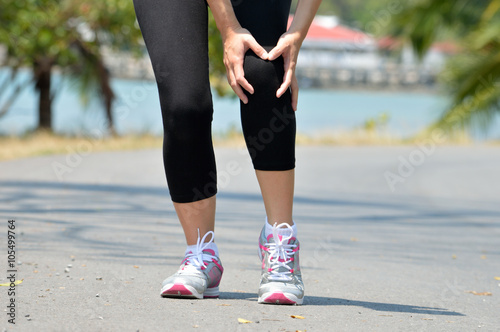 Woman runner hold her sports injured knee