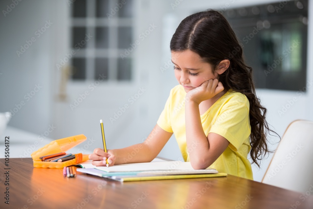 Girl studying while sitting at desk 
