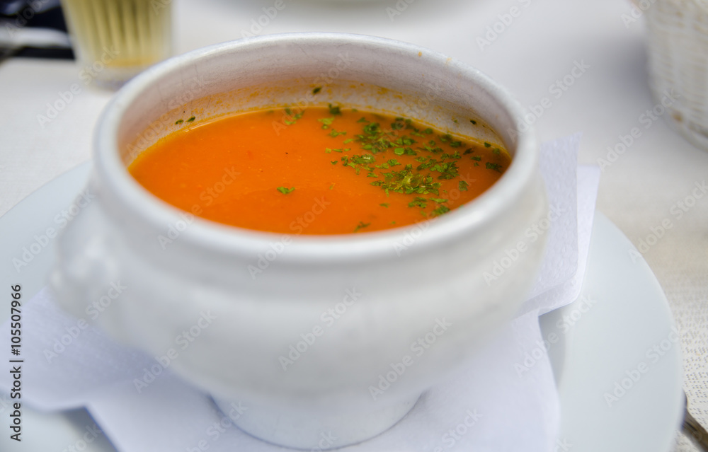 Pumpkin soup and parsley leaf in a white bowl Pumpkin soup and parsley leaf in a white bowl