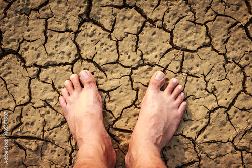 Naked human barefeet on dry soil