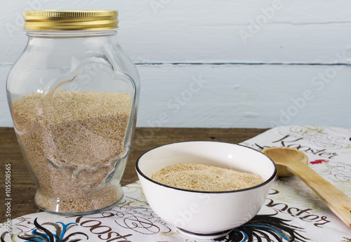 Uncooked oatbran on rustic wood table photo