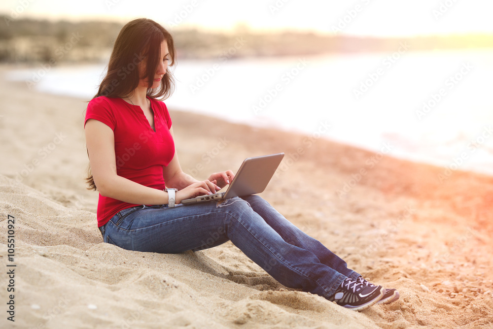Woman working with laptop notebook on a beach