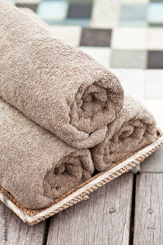 Brown towels in wicker basket at a luxury swimming pool