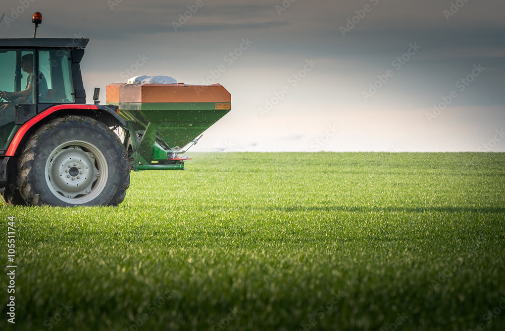 Obraz premium tractor fertilizing in field