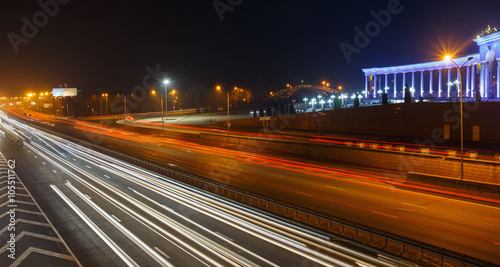 Evening view of the Almaty city. Park of first president. Light trails on motorway highway at night.
