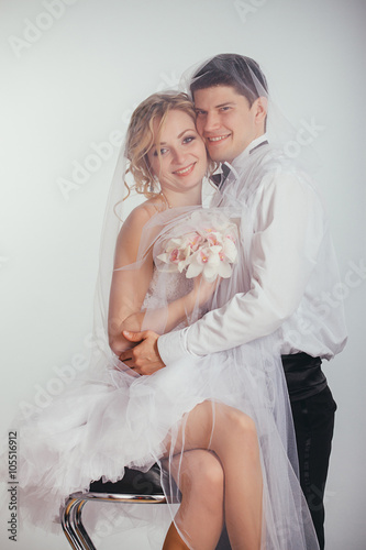 couple of bride and groom covered with veil photo