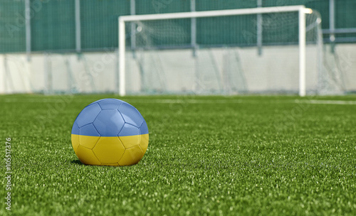 Soccer ball on the green field- flag Ukraine