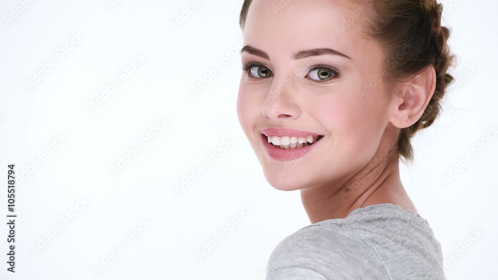 Young and beautiful woman smiles and flirts in front of the camera over white background Young and beautiful woman smiles and flirts in front of the camera over white background