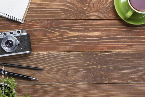 Travel, vacation concept. Camera and supplies on office wooden desk table. Top view with copy space for text