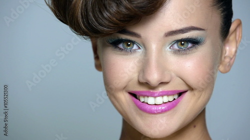 Closeup face of a beautiful expressive girl winks of one eye. Portrait of a caucasian woman with flirt behavior. Full hd video clip.