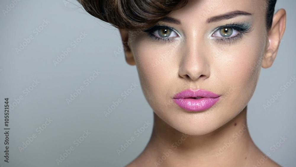 Closeup face of a beautiful  girl with blue eye makeup and pink lips. Full hd video clip.