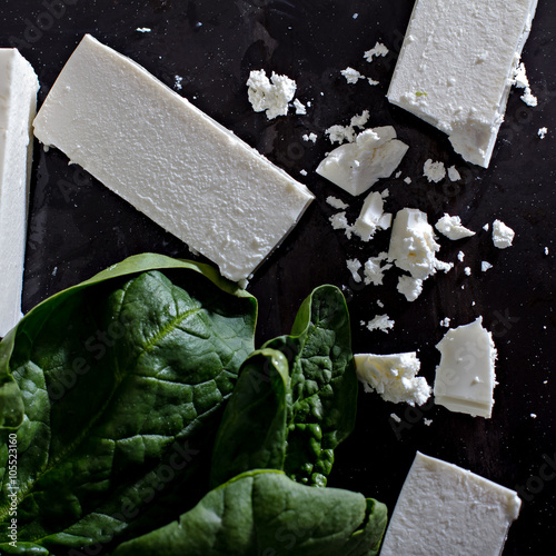 Fresh spinach and feta cheese on a black background