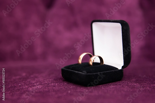 Engagement gold rings on purple background © protivnica