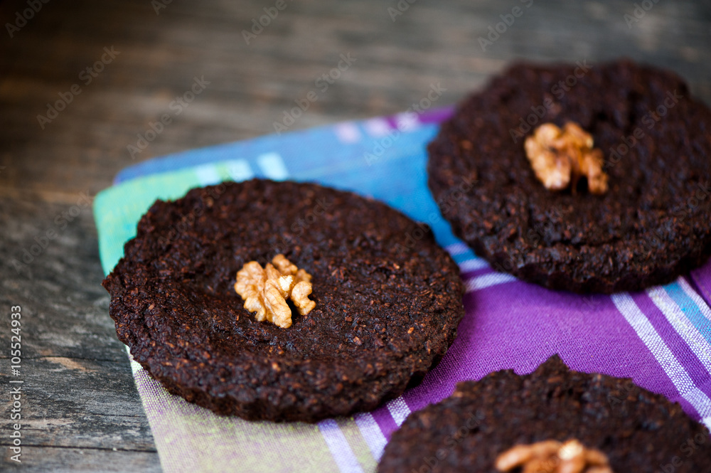 Round homemade brownies with walnuts on a rustic background