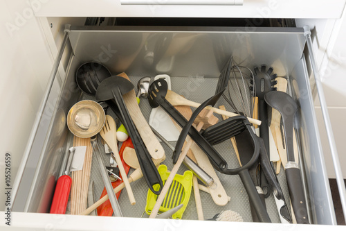 Opened drawer full of kitchenware