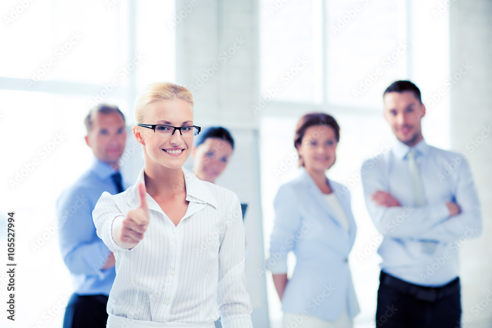 businesswoman in office showign thumbs up businesswoman in office showign thumbs up